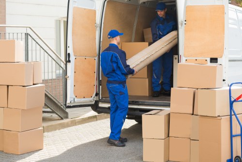 Removal team handling household moving boxes and furniture in Streatham